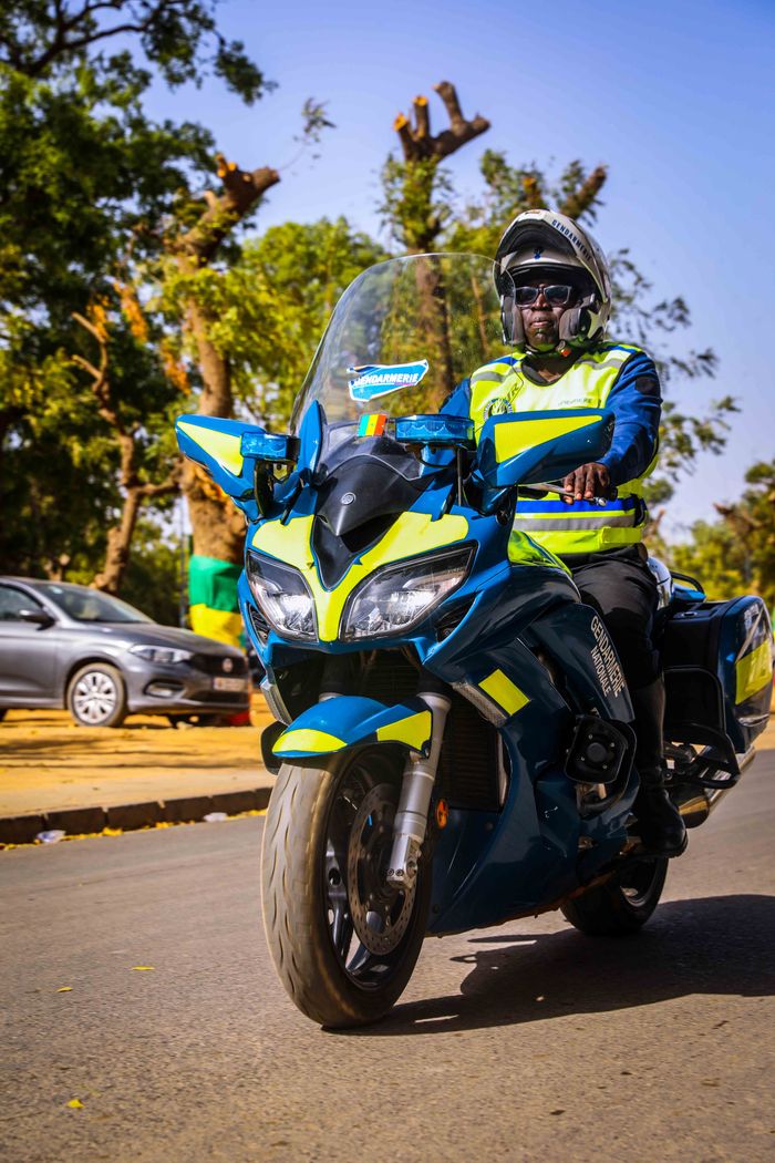 services-02 Police officer on a motorcycle patrols a city street during the day.